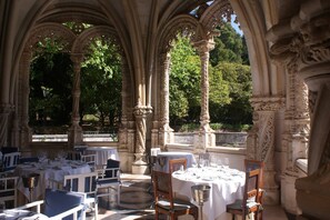 An outdoor dining area with stone arches and tables set for a meal. - Holiday Home in Covas with Eco Pool (Covas)