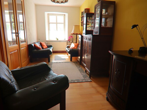 A living room with a sofa, a coffee table, a cabinet, and a lamp. - Alt Krassow Lakeside Retreat (Alt Krassow / Lalendorf)