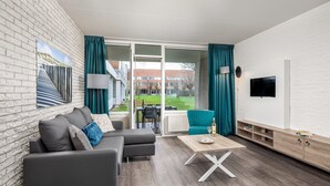 A modern living room with a grey sectional sofa, a wooden coffee table, and teal curtains.