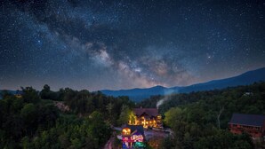 A house with a starry night sky, surrounded by dense forest. - Incredible Sunset Views | Organic Decor | Arcades (Sevierville)