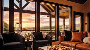 A spacious room with large windows, a wooden ceiling, and a variety of seating options. - Incredible Sunset Views | Organic Decor | Arcades (Sevierville)