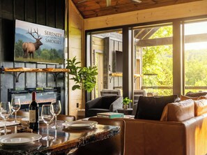 Una habitación acogedora con chimenea, una mesa de comedor para cuatro personas y un espacio de estar confortable.