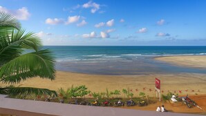 Una playa con cielo despejado, palmeras y un cartel que indica una zona junto a la playa.