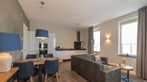 A modern apartment with a dining area, sofa, and kitchen. - Apartment in Colijnsplaat near Lake and Sauna (Colijnsplaat)