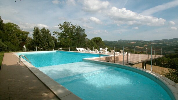 Ein Swimmingpool mit Blick auf Hügel und Bäume.