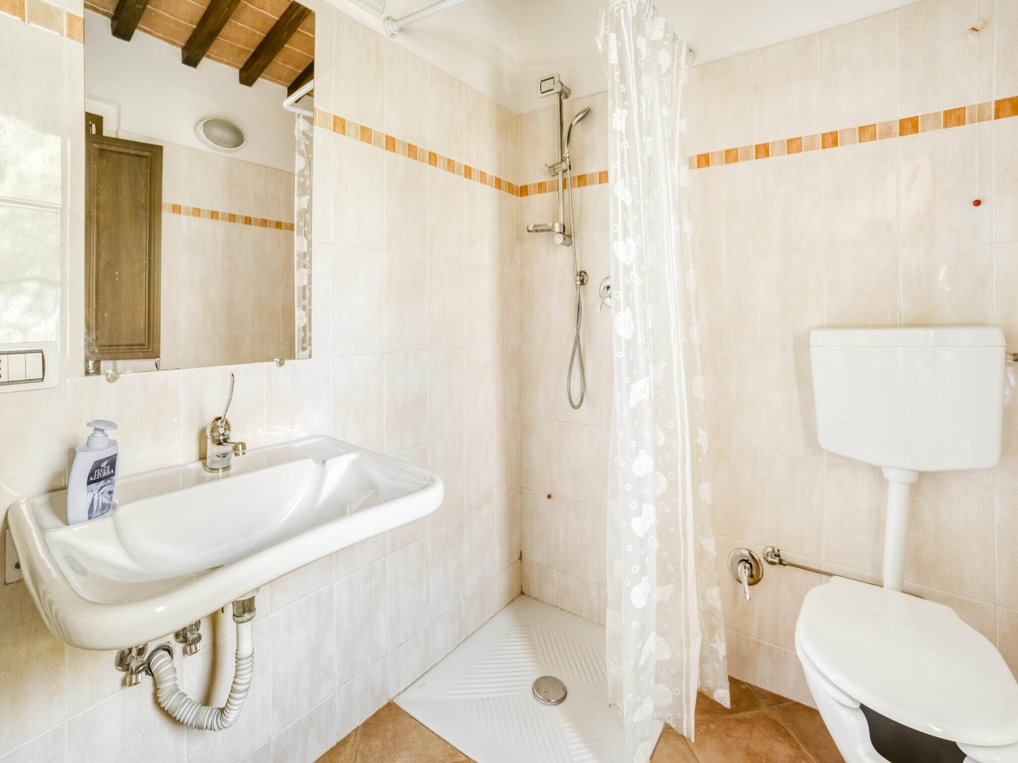 Ein Badezimmer mit Dusche, Toilette und Waschbecken.