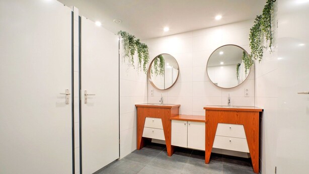 A modern bathroom with two sinks, wooden vanity, white cabinets, and mirrors. - Spacious Group Getaway with Garden (Ulestraten)