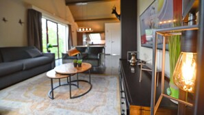 Un salon moderne avec un canapé, une table basse ronde et un coin repas comprenant une table et des chaises.