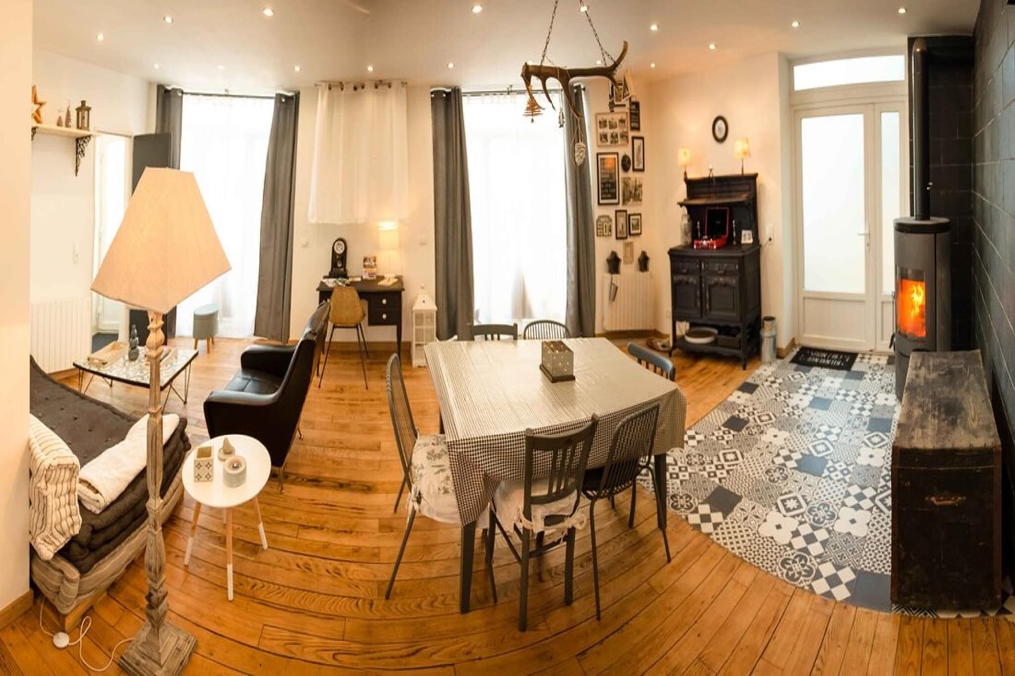 A cozy living room with a fireplace, a dining area with a table and chairs, and a sofa.