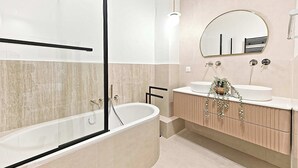 A modern bathroom with a freestanding bathtub, two sinks, a large mirror, and a light fixture. - New flat with AC Porte Maillot/Arc de Triomphe (Paris)