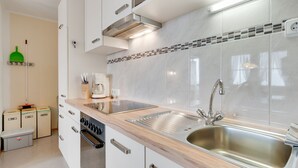A modern kitchen with white cabinets, a stainless steel sink, a built-in oven, and a coffee maker. - Apartment in Hainzenberg near Ski Lift (Hainzenberg)