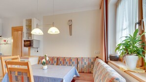 A cozy dining area with a bench, table, chairs, and a potted plant. - Apartment in Hainzenberg near Ski Lift (Hainzenberg)
