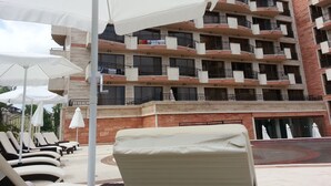 A multi-story hotel with balconies, outdoor seating, and a pool area. - River Park - Menada Apartments (Sunny Beach)