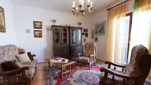 A traditional living room with a wooden sofa, two armchairs, a coffee table, a cabinet with glass doors, and a chandelier. - Apartment with terrace near the beach (Malinska)