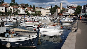 A marina with multiple boats docked, surrounded by buildings and a clear sky. - Apartment with terrace near the beach (Malinska)