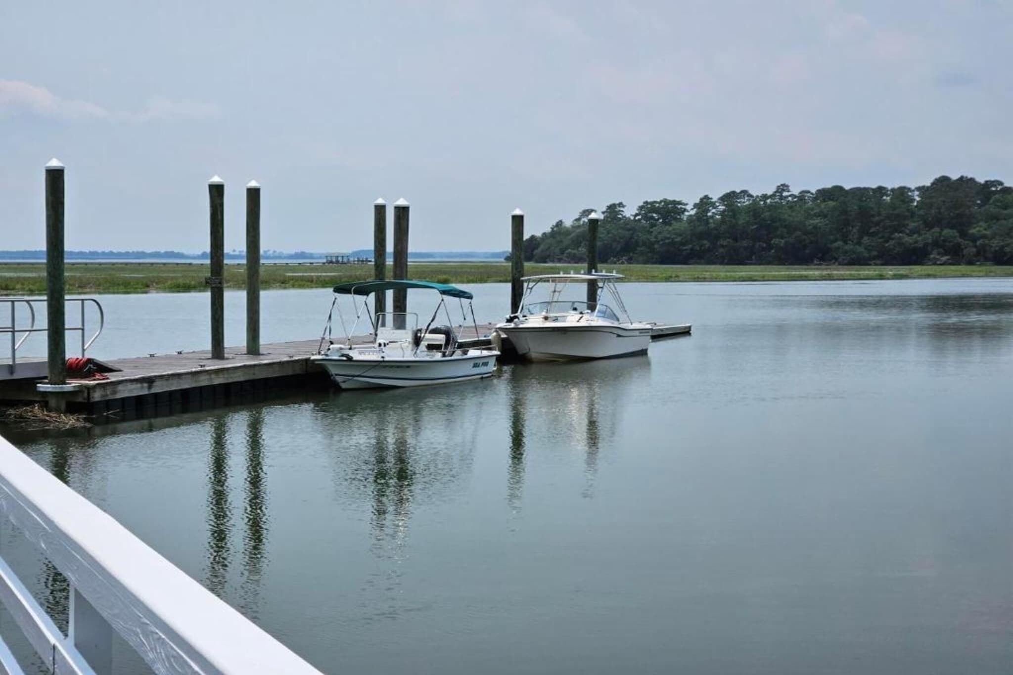 A calm water body with two boats docked at a pier.