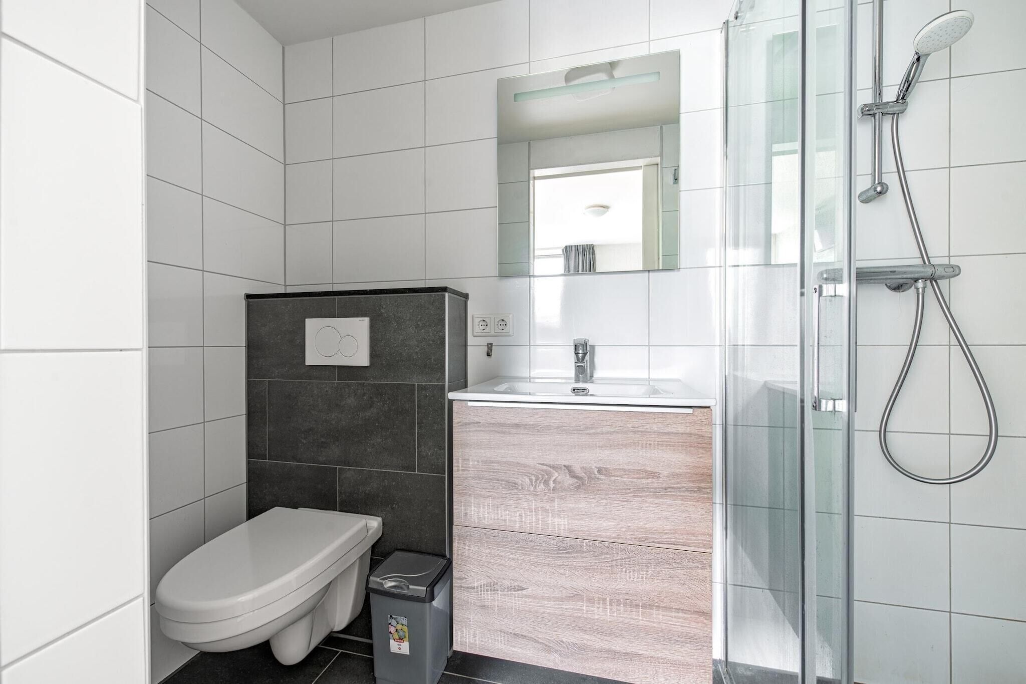 A modern bathroom with a toilet, sink, and shower.