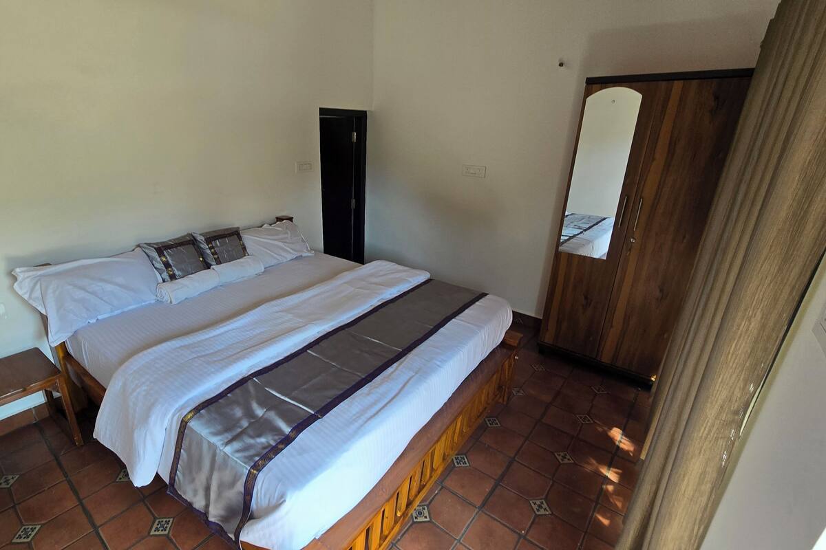 Ein Schlafzimmer mit einem Bett, einem Holzschrank und einer Tür.