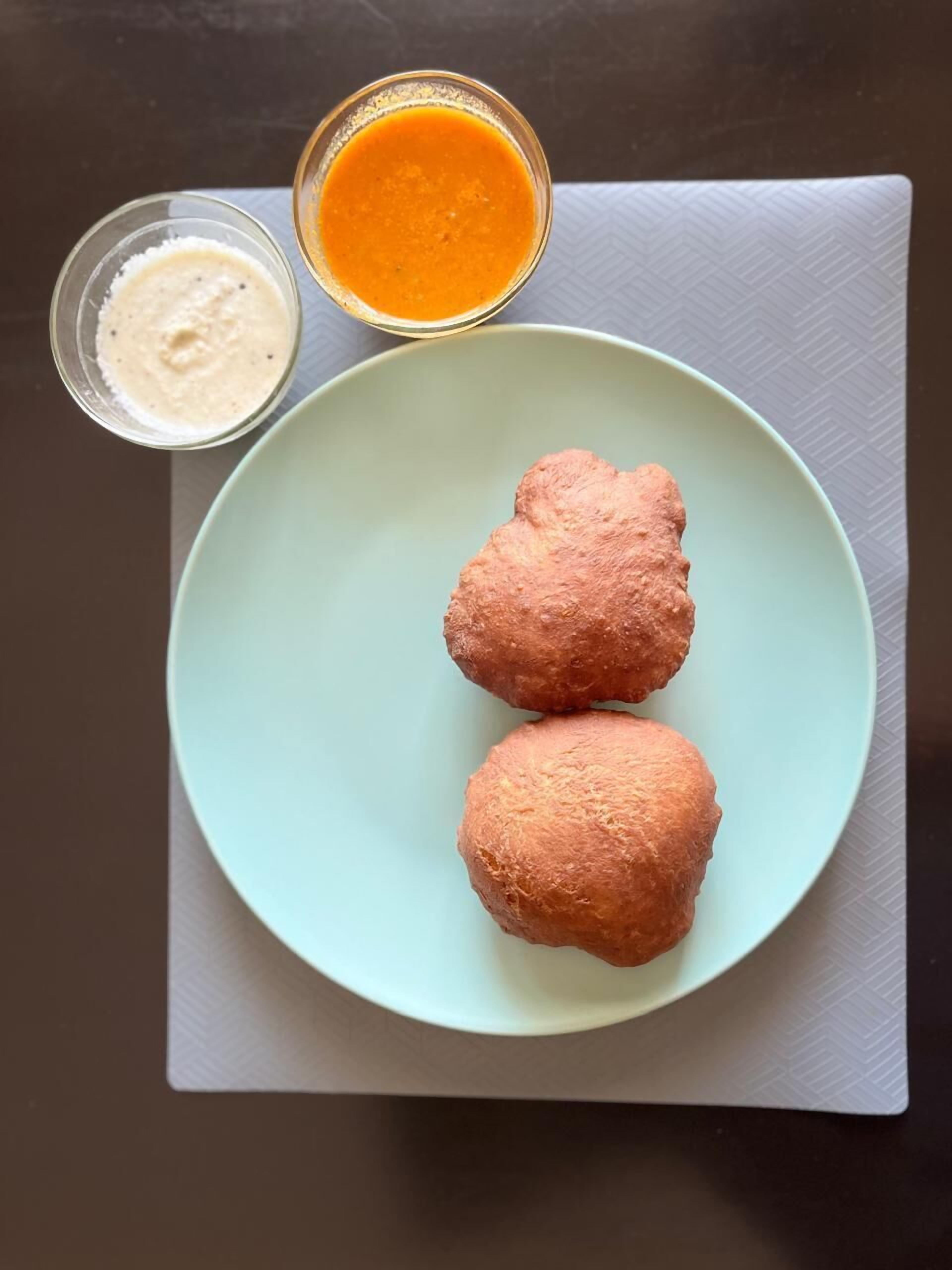 Deux aliments frits présentés sur une assiette bleu clair, accompagnés de deux petits ramequins de sauces.