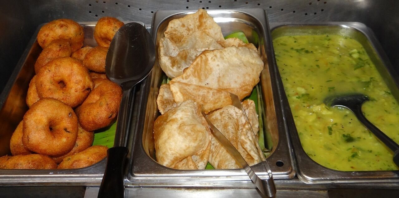 Un buffet proposant des plats frits et une soupe verte.