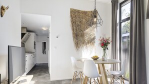 A modern kitchen with white cabinets, a built-in oven, and a stainless steel range hood.