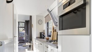 A modern kitchen with stainless steel appliances, a built-in oven, and a gas stove.