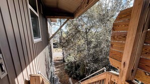 A wooden deck leading to a house with a view of trees and a clear sky. - Bay Views, Short beach walk, 3/2, Community Pool (Port St. Joe)