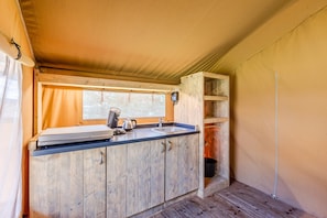 A compact kitchen with wooden cabinets, a sink, and a window.