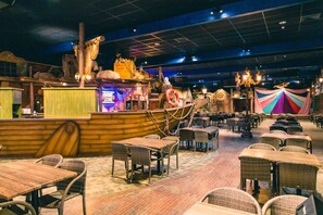 Enjoy dining and entertainment in this nautical-themed space with a bar counter, wicker tables, and a stage area.