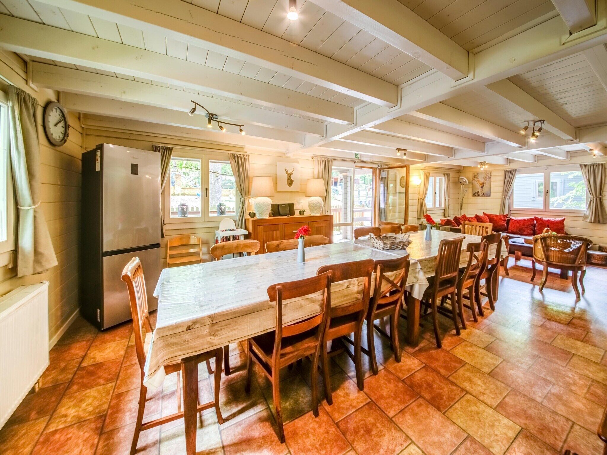 A spacious kitchen with a large island, wooden chairs, and a dining table.