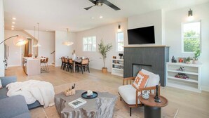 A spacious living area with a fireplace, a dining area, and a kitchen. - 4 BDR Stay for 12 w/Rooftop Patio Firepit! Near DT (Nashville)