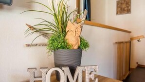 Uma planta em vaso com uma decoração de coruja de madeira sobre uma mesa de madeira, com a palavra 'HOME' escrita em letras.