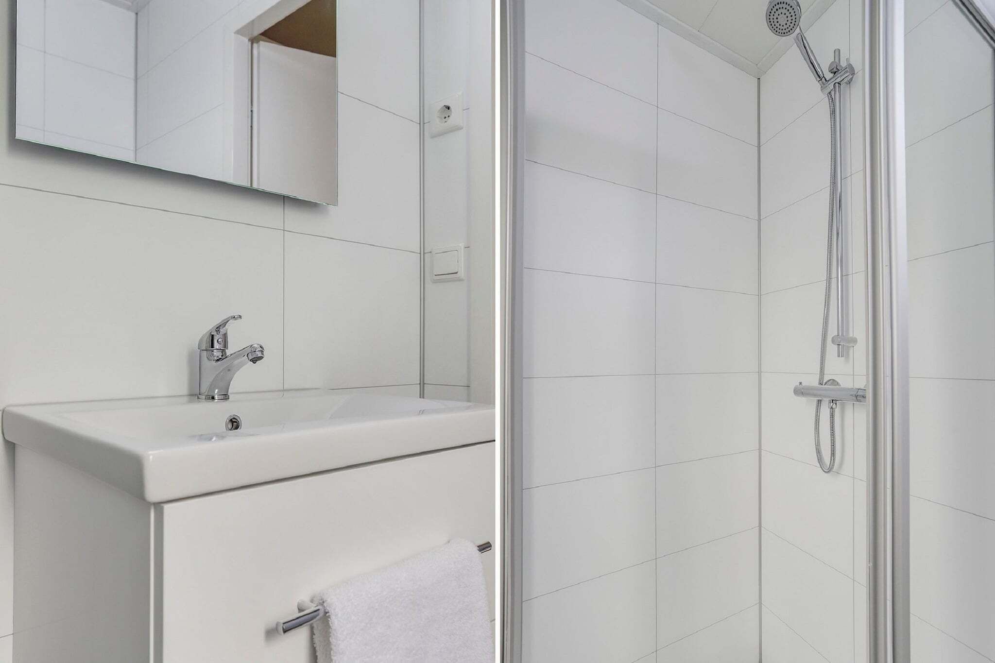 A bathroom with a white sink, mirror, and shower.
