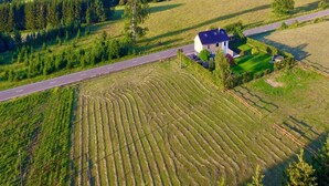 An aerial view of a rural landscape with a house, a road, and terraced fields. - Holiday Home in Manhay near Ski Area (Manhay)