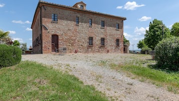 Un bâtiment en pierre avec un chemin de gravier menant à l’entrée.