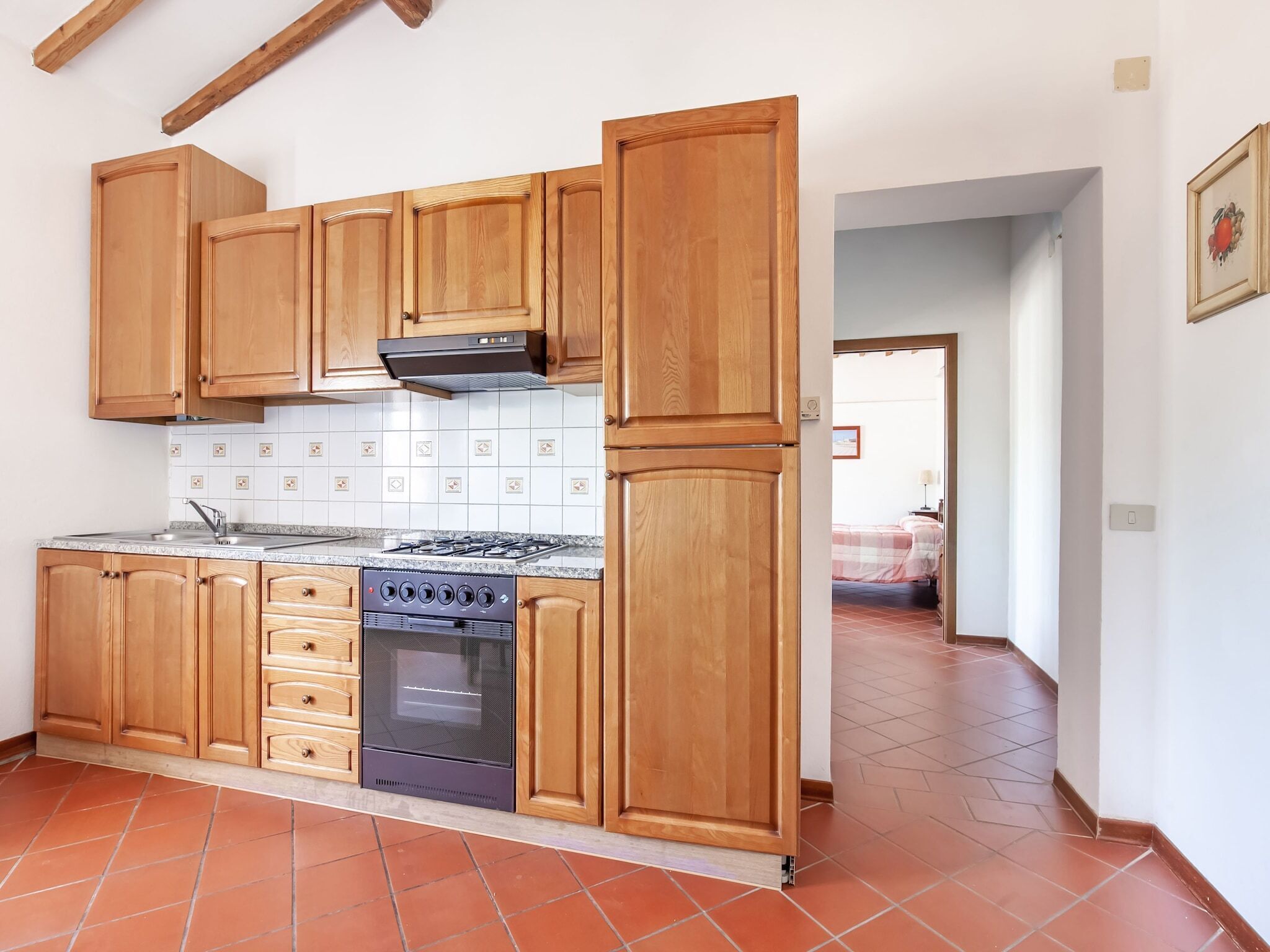 A kitchen with wooden cabinets, a gas stove, and a built-in oven.