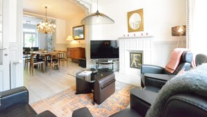 Een woonkamer met een televisie, bank en een open haard.