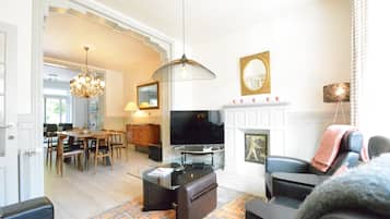 Un salon avec une télévision, un canapé et une cheminée.