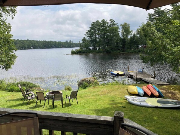 A lakeside view with a dock, chairs, and kayaks. - Cold Stream Cottage: A Serene Lakeside Escape (Lincoln)