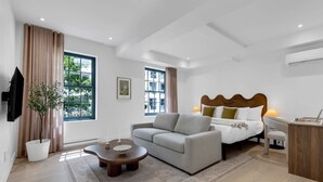 Una habitación de hotel moderna con cama, sofá y una mesita.