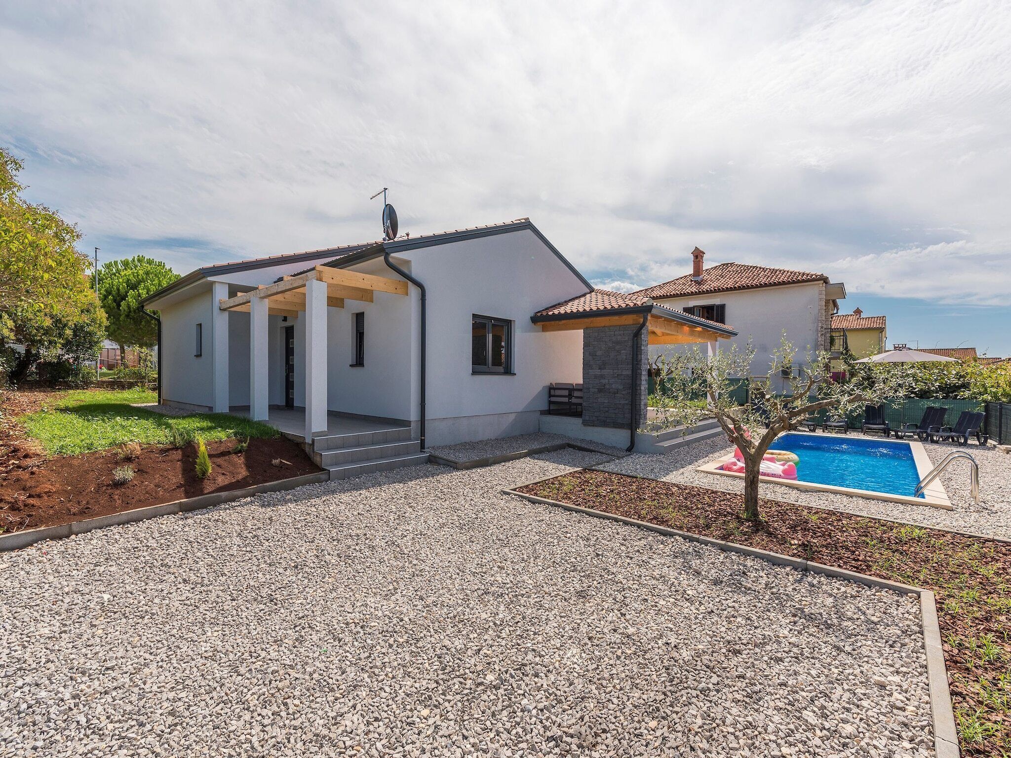 A modern two-story house with a covered patio and a swimming pool.