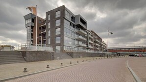 Un edificio moderno de varios pisos con fachada de ladrillo y grandes ventanales.