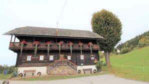 A wooden chalet with a balcony, a stone staircase, and a bench outside. - Apartment in Fresach near Ski Slopes (Fresach)