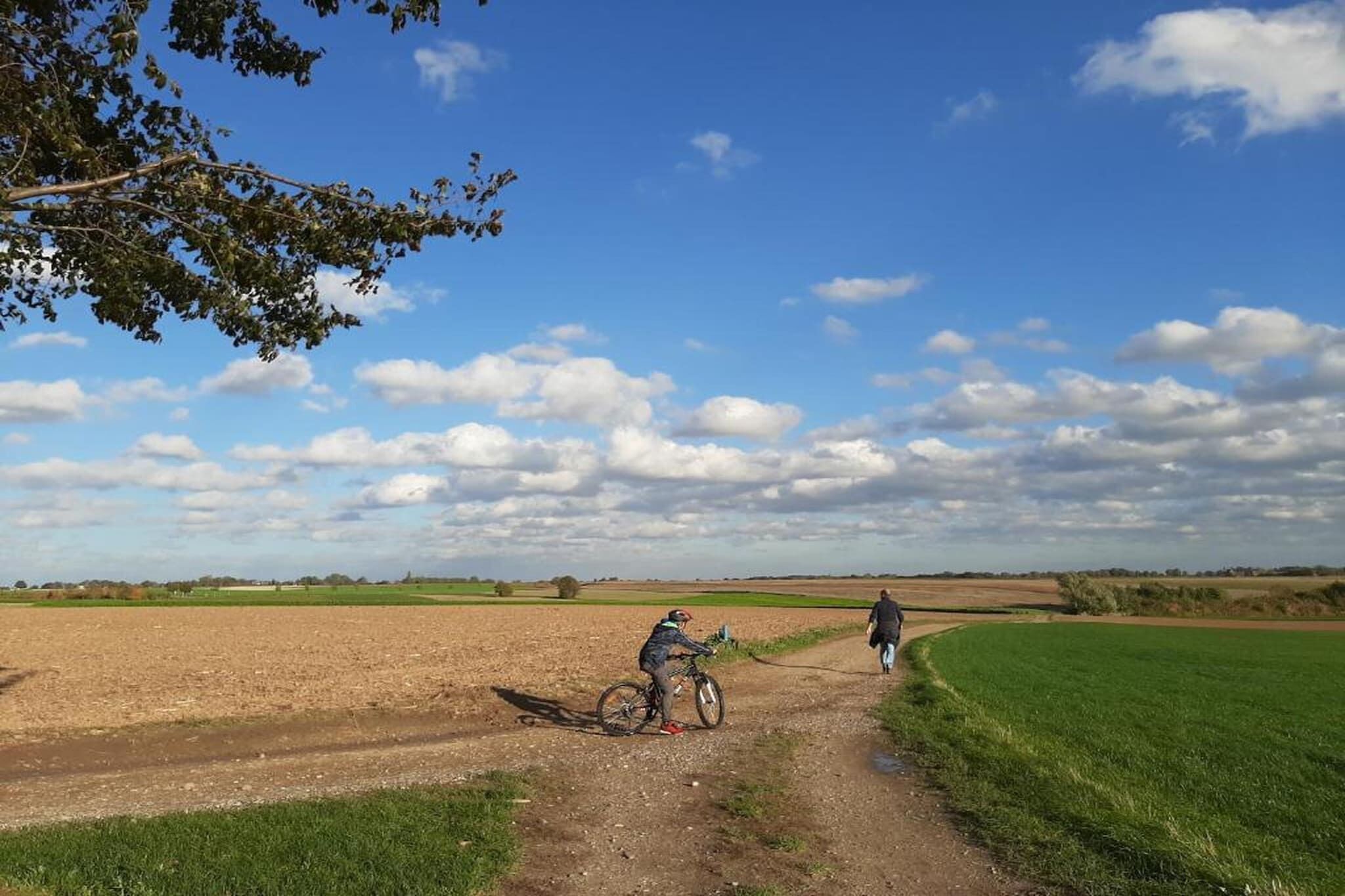 Een landweg met fietsers en een wandelaar.
