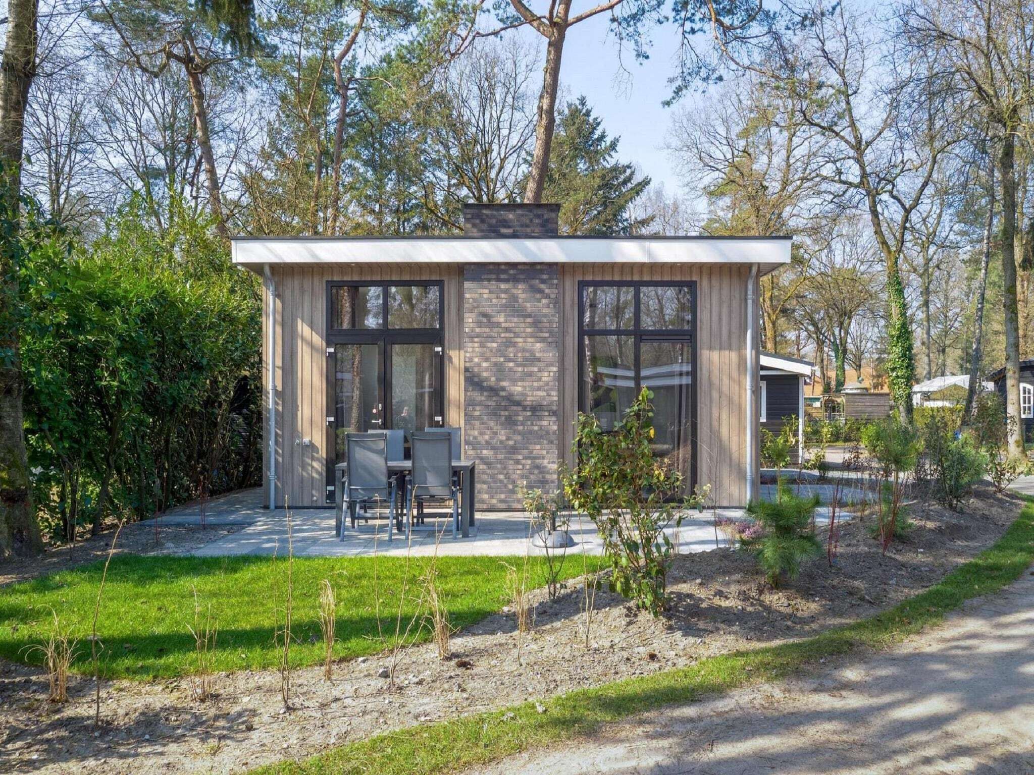 A modern house with a patio, large windows, and a garden.