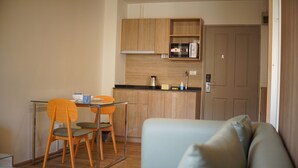 A compact living space with a kitchenette, a dining area with two chairs, and a sofa. - The Parkland Bangna Next MRT Station (Bangkok)