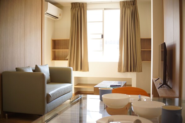 Apartamento luxo, 1 quarto, ar-condicionado, vista para a cidade | Área de estar | TV de tela plana 32 polegadas com canais a cabo