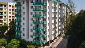 A multi-story hotel with balconies, a flat roof, and a green and white color scheme. - The Parkland Bangna Next MRT Station (Bangkok)