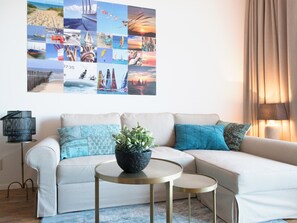 A living room with a sofa, a coffee table, and a wall collage.