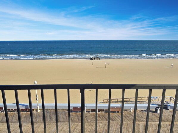 A beach view from a balcony with a wooden deck, a sandy beach, and the ocean. - Direct Oceanfront and Boardwalk Condo on 12th St. with Indoor Pool! Decatur House 505 (Ocean City)